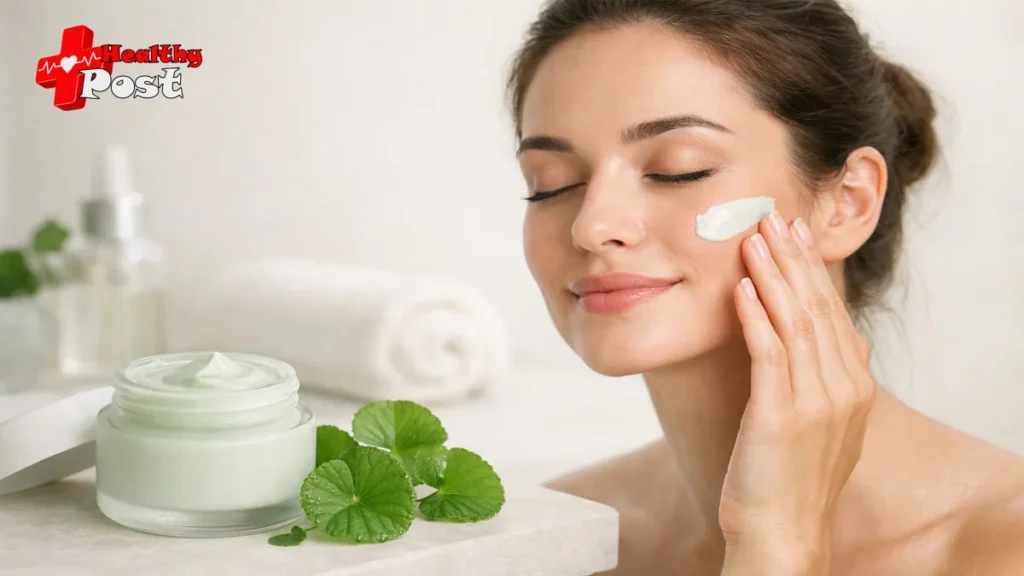 A woman with smooth skin applying a light green Centella Asiatica cream to her cheek next to an open jar of cica moisturizer and fresh green tiger grass leaves.
